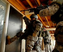 SWAT breaking down a door as a military-style action.